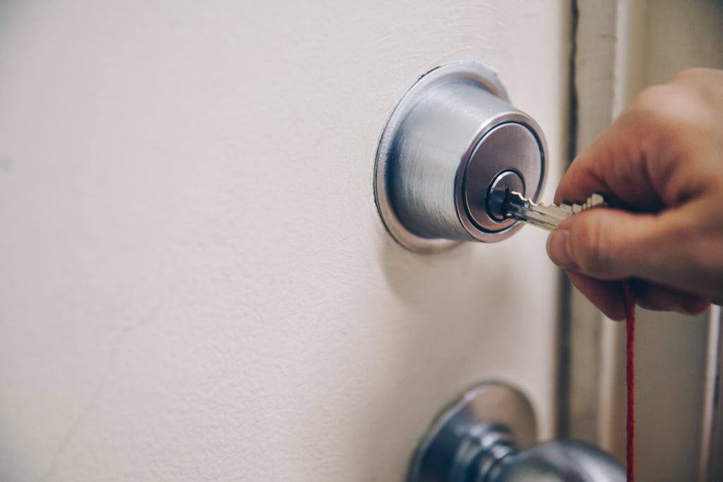 Hand putting key in lock in door